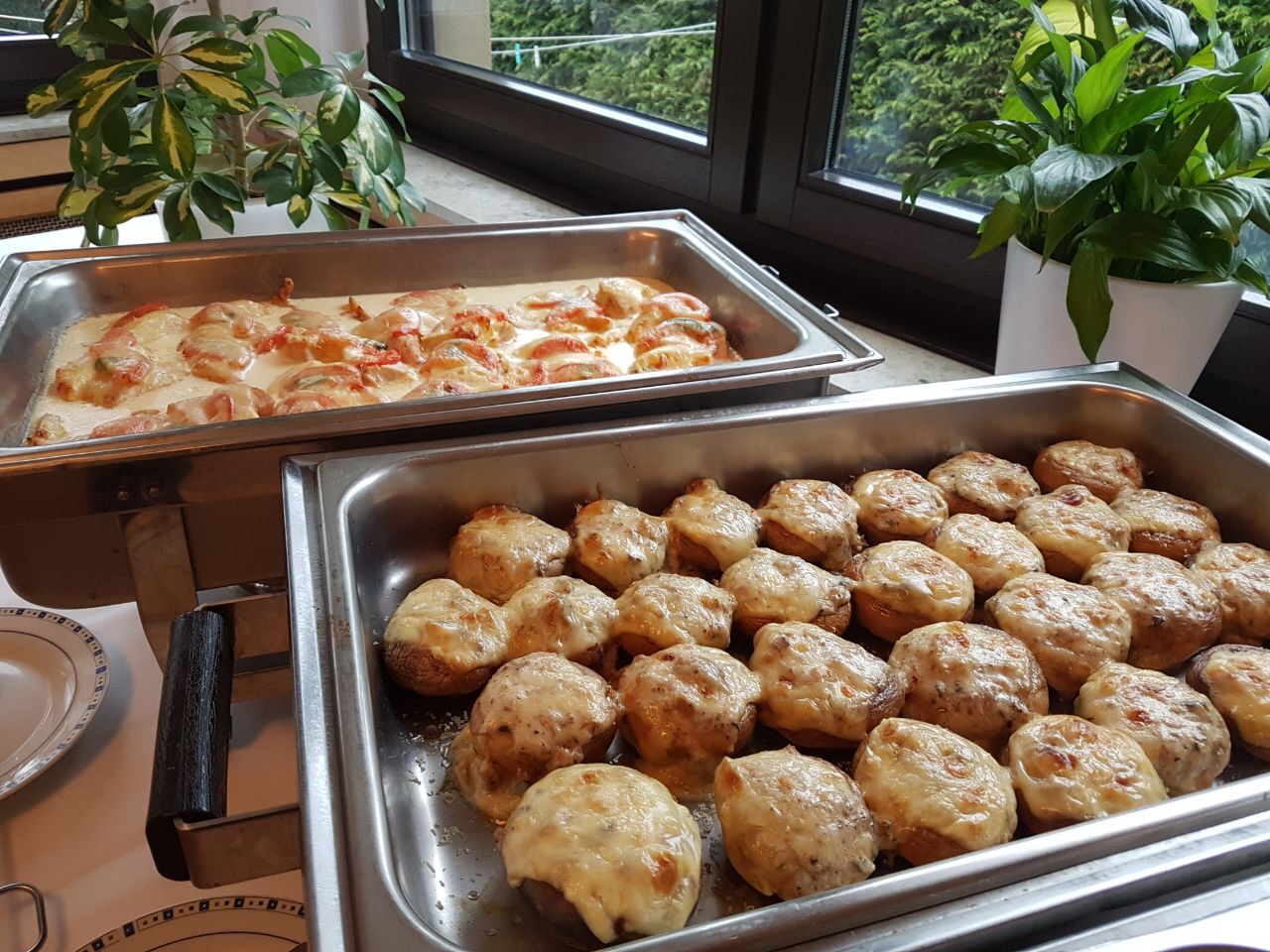 spargelbuffet-02 Zwei Tabletts mit gefüllten Pilzen und einem Auflauf auf einem Buffet.