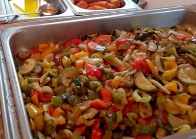 Eine Schale mit gemischtem Gemüse, darunter Paprika, Zucchini und Karotten in verschiedenen Farben.